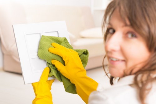 Cleaner wearing PPE while protecting a customer’s flooring and furniture